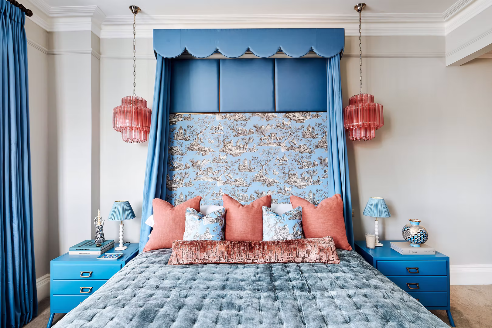 Four-poster bed dressed with a blue scalloped canopy and bespoke upholstered details